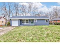 Charming one-story home with blue brick, covered porch, attached garage, and well-maintained lawn at 6503 W 15Th St, Indianapolis, IN 46214