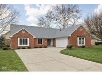 Charming brick home featuring an attached two car garage and well maintained lawn and driveway at 6628 Moss Cir, Indianapolis, IN 46237