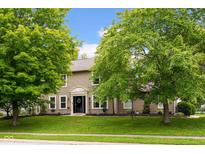 Charming two-story home with a well-manicured lawn and beautiful, mature trees at 7383 Poppyseed Dr, Indianapolis, IN 46237