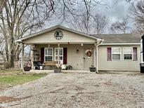 Charming single-story home with covered porch, decorative accents, and gravel driveway at 964 Center St, Martinsville, IN 46151