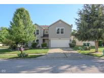 Charming two-story home with mature trees, a well-maintained lawn, and a two car garage at 10309 Buckshire Ln, Indianapolis, IN 46234