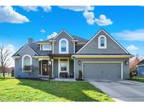 Charming two-story home with manicured lawn, attached garage, and a covered entry at 1377 Edinburgh Dr, Carmel, IN 46033
