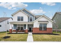 Charming two-story home with a cozy front porch, brick accents and manicured lawn at 2156 W 171St St, Westfield, IN 46074