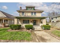 Charming two-story home with a brick facade, front porch and well-maintained landscaping at 2620 Central Ave, Indianapolis, IN 46205