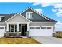 Charming two-story home featuring a two-car garage and covered porch with stone accents and stylish gray siding at 268 Onset Way, Westfield, IN 46074