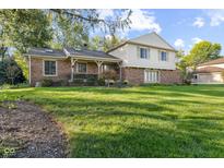 Charming two-story home featuring a brick facade, manicured lawn, and inviting porch at 3453 Briar Creek Ln, Carmel, IN 46033
