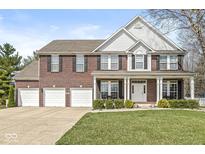 Charming brick two-story home with a three-car garage and inviting front porch at 3998 Jonathan Rdg, Columbus, IN 47201