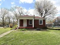 Charming brick home with a covered porch and a well-maintained lawn at 5368 Southeastern Ave, Indianapolis, IN 46203