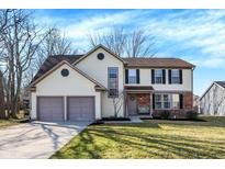 Charming two-story home featuring a two-car garage, well-manicured lawn, and inviting front porch at 8623 Appleby Ln, Indianapolis, IN 46256
