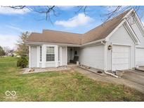 Charming home with a well-maintained lawn, attached garage, and inviting front entrance at 9010 Kiser Pt, Indianapolis, IN 46256