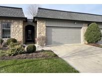 Charming home exterior with stone accents, attached garage and tidy landscaping at 1054 Carters Grove, Indianapolis, IN 46260