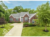 Charming brick home features a well-manicured lawn, mature trees, and a long driveway at 1361 Colinbrook Ct, Greenwood, IN 46143