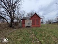 An exterior view of a derelict, boarded-up home, in need of significant repair at 1724 Sheldon St, Indianapolis, IN 46218