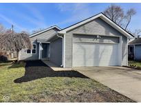 Charming home featuring gray siding, attached two-car garage, and manicured front yard at 2620 E 56Th St, Indianapolis, IN 46220