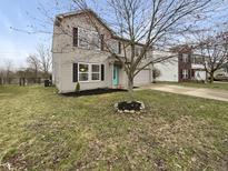 Charming two-story home featuring a well-maintained lawn, black mulch and a light blue front door at 3313 Capsella Ln, Indianapolis, IN 46203