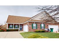 Charming brick house with a two-car garage, manicured lawn, and inviting front porch with green shutters at 5180 Dunewood Way # 57, Avon, IN 46123