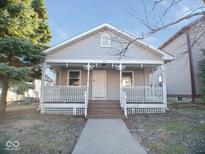 Charming home with a covered front porch, white railings, and neutral-colored siding at 55 S 4Th Ave, Beech Grove, IN 46107