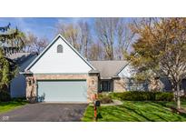 Charming single-story home with brick facade, light blue accents, and an attached two-car garage at 7616 Newport Bay E Dr, Indianapolis, IN 46240