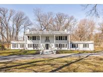 Stately two-story white home featuring classic architectural details and a large front yard with a circular driveway at 8020 N Meridian N St, Indianapolis, IN 46260