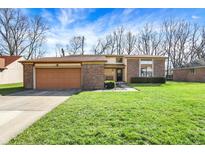 Charming single-story home with brick accents, a two-car garage, and a well-maintained front lawn at 8539 Chateaugay Dr, Indianapolis, IN 46217