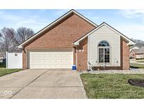 Charming brick home featuring a two-car garage, well-maintained lawn, and decorative window at 906 Claiborne Ln, Lebanon, IN 46052