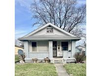 Charming single-story home featuring a covered front porch and decorative yard planters at 1409 N Denny St, Indianapolis, IN 46201