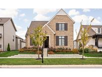 Charming brick home with manicured lawn, tasteful landscaping, and classic architectural details at 15628 Allegro Dr, Westfield, IN 46074