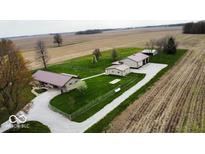 Sprawling rural property featuring multiple buildings, green lawns, and surrounding farmland at 18103 N 300 W, Summitville, IN 46070