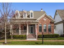 Charming brick home with inviting front porch and manicured landscaping creates a welcoming curb appeal at 4030 Statesmen Dr, Indianapolis, IN 46250