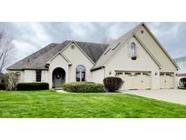 Charming single-Gathering home boasts a well-manicured lawn, arched entryway, three-car garage, and a beautifully landscaped front yard at 5949 Willow Bend Dr, Avon, IN 46123