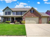 Two-story home featuring a well-manicured lawn, brick accents, and a spacious three-car garage at 7233 Capel Dr, Indianapolis, IN 46259