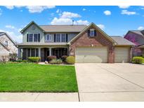 Charming two-story home with a well-manicured lawn and a three car garage at 7233 Capel Dr, Indianapolis, IN 46259