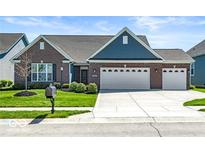 Charming brick home featuring a three-car garage and well-maintained lawn at 7447 Starkey Ct, Indianapolis, IN 46278