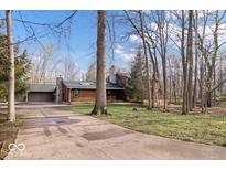Charming log cabin style home with stone chimney and a driveway at 98 Highland Manor S Ct, Indianapolis, IN 46228