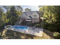 Expansive aerial view showcases a beautiful home with a pool, outdoor seating, and mature trees at 1143 N Sugar Bend Run, Greenfield, IN 46140