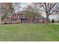 Charming two-story brick home with a well-manicured lawn and mature trees in a desirable neighborhood at 1401 Shadow Ct, Zionsville, IN 46077
