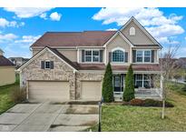 Beautiful two-story home with a three-car garage, brick accents, and manicured lawn at 14462 Camden Ln, Carmel, IN 46074