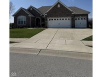 Charming single-story brick home with a spacious three-car garage and well-manicured lawn at 15085 Thoroughbred Dr, Fishers, IN 46040