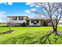 Charming two-story home with a lush green lawn, mature trees, and welcoming front porch on a bright day at 1585 S 600 W, New Palestine, IN 46163