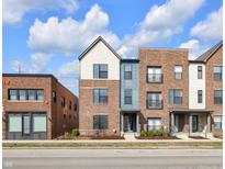 Attractive exterior view of brick townhomes with blue siding accents and well-maintained landscaping on a sunny day at 1842 Central Ave, Indianapolis, IN 46202