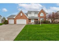 Charming two-story brick home featuring an attached three-car garage and a lush green lawn at 222 Wellington Pkwy, Noblesville, IN 46060