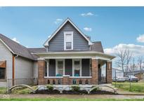 Charming two-story home with gray siding, brick foundation and inviting front porch at 234 S State Ave, Indianapolis, IN 46201