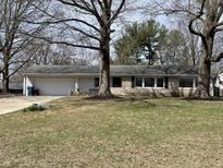 Charming single-story home with stone facade, attached garage, and mature trees at 3516 Circle Blvd, Indianapolis, IN 46220