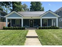 Charming single-story home featuring a metal roof, front porch, and well-manicured lawn at 3535 Birchwood Ave, Indianapolis, IN 46205