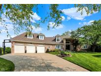 Charming brick home with a four car garage, lush landscaping and beautiful curb appeal at 3862 Penzance Pl, Carmel, IN 46032