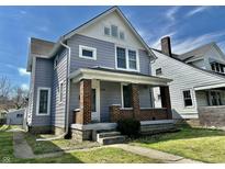 Charming two-story home with brick and gray siding under a blue sky, showcasing its curb appeal at 418 N Drexel Ave, Indianapolis, IN 46201