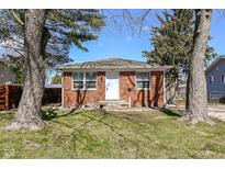Charming brick ranch home with a well-manicured lawn and mature trees at 4414 Lexington Ave, Indianapolis, IN 46203