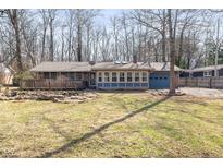 Charming single story home features a sunroom and a blue attached garage and a cozy wooden deck at 4631 Berkshire Ln, Indianapolis, IN 46226