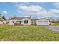 Charming single-story home featuring a front porch swing and a detached two-car garage at 5902 Sunset Dr, Indianapolis, IN 46239