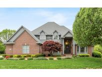 Charming brick home featuring lush landscaping, a well-manicured lawn, and an elegant front entrance at 6010 Fawnwood Dr, Greenwood, IN 46143